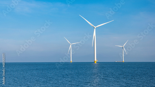Windmill farm in the ocean Westermeerwind park, windmills isolated at sea on a beautiful bright day in the Netherlands Flevoland Noordoostpolder. Huge windmill turbines at sea