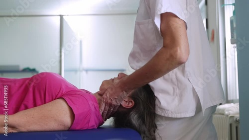 Focused clip of the nurse hands giving a massage to her middle age patient for recover her neck injury. photo