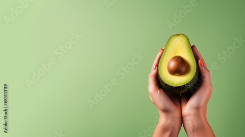 Hand holding avocado fruit isolated on pastel background