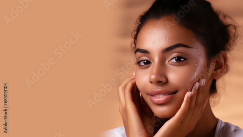 Indian woman with a healthy glowing skin apply a skincare product