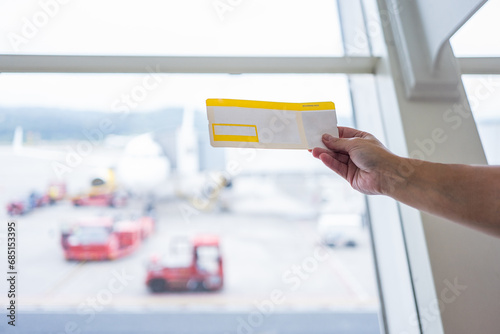 Unrecognizable tourist holding flight ticket