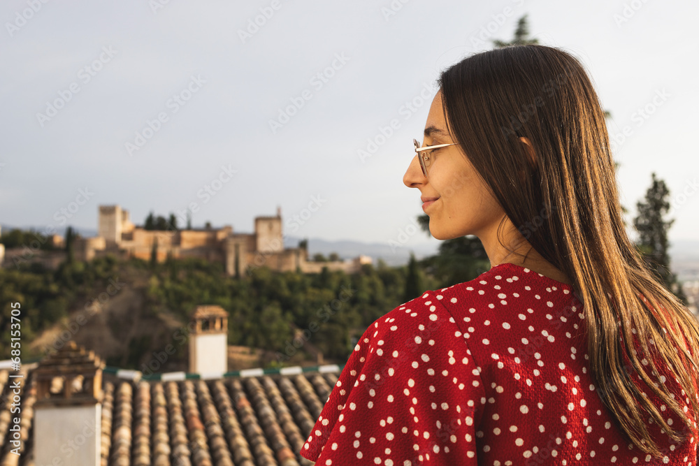 Side view of happy tourist standing against historic Alcazaba while enjoying vacation in Granada, Spain Side view of happy tourist standing against historic Alcazaba while enjoying vacation in Granada, Spain