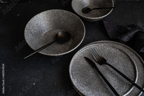 Modern dark tableware setup on a black background photo