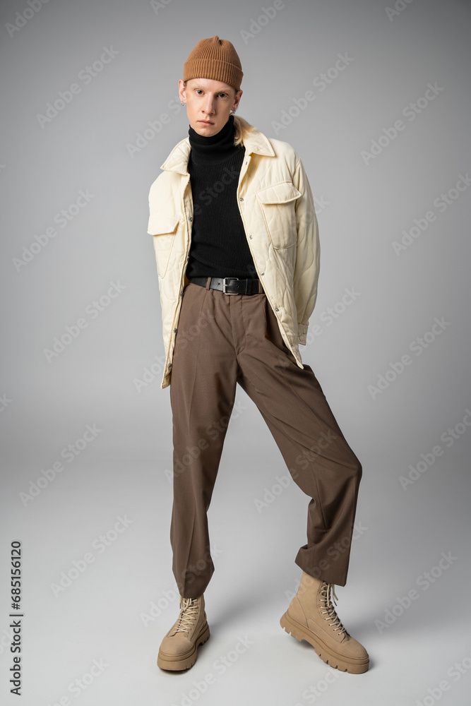 vertical shot of non binary stylish person in winter attire posing and looking at camera, fashion vertical shot of non binary stylish person in winter attire posing and looking at camera, fashion