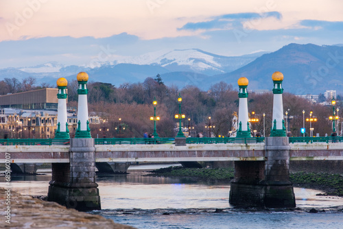 View of Kursaal zubia Bridge in San Sebastián, Spain, with the range of mountains in the background. photo