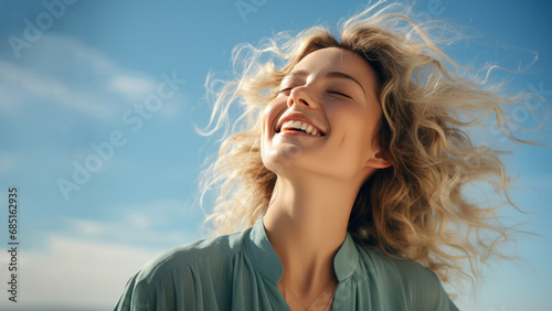 A Blonde woman breathes calmly looking up isolated on clear blue sky photo