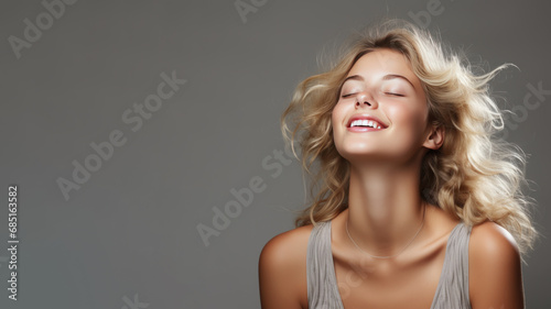 A Blonde woman breathes calmly looking up isolated on gray background
