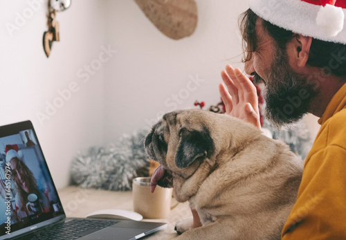 One woman doing video call on laptop with his old dog pug best friends and happy woman on the other side of computer connection display. Remote friends during christmas holiday celebration time