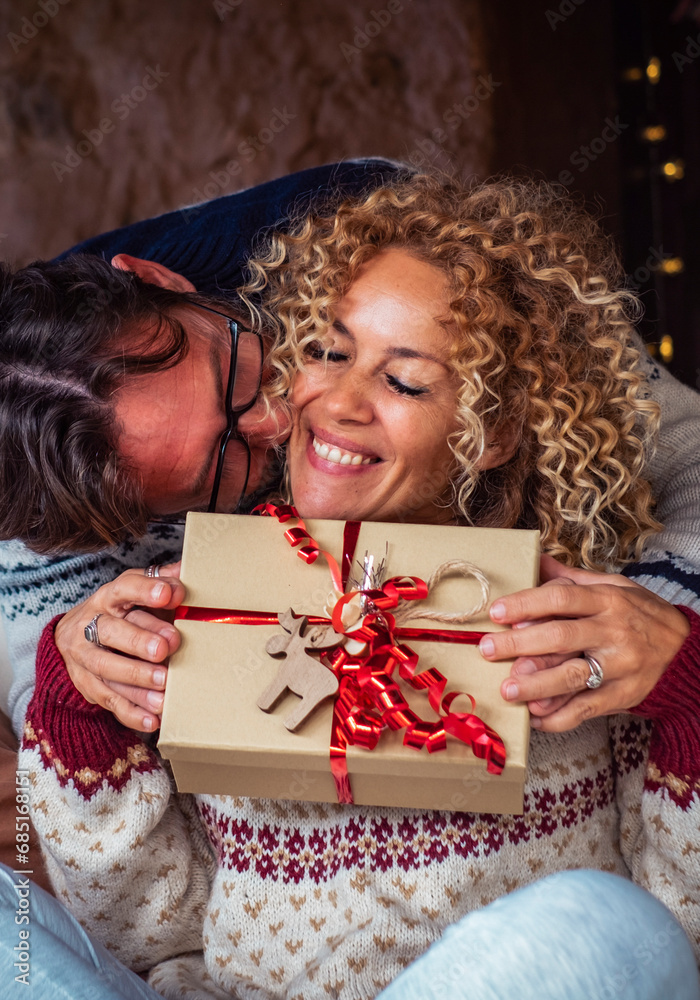 One man doing surprise gift to a woman in christmas eve night celebration. Happy couple enjoy december holiday celebration at home together with love and joy. Concept of box present and Relationship One man doing surprise gift to a woman in christmas eve night celebration. Happy couple enjoy december holiday celebration at home together with love and joy. Concept of box present and Relationship