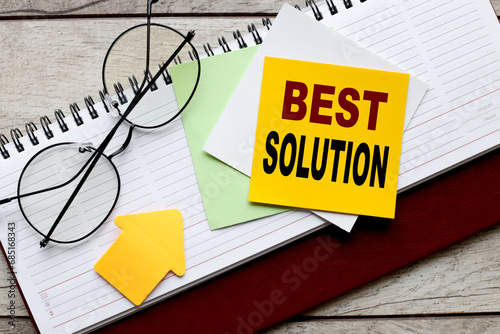 paper for writing on a notepad. glasses on the working table. text best solution
