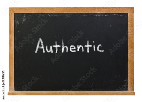 Authentic written in white chalk on a black chalkboard isolated on white