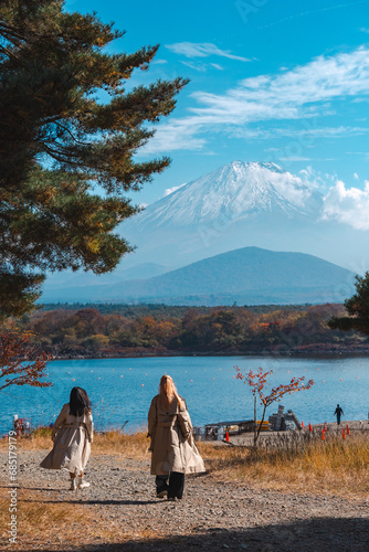 Wall Mural Happy tourist traveler woman or man enjoying on lake kawaguchiko with mount fuji