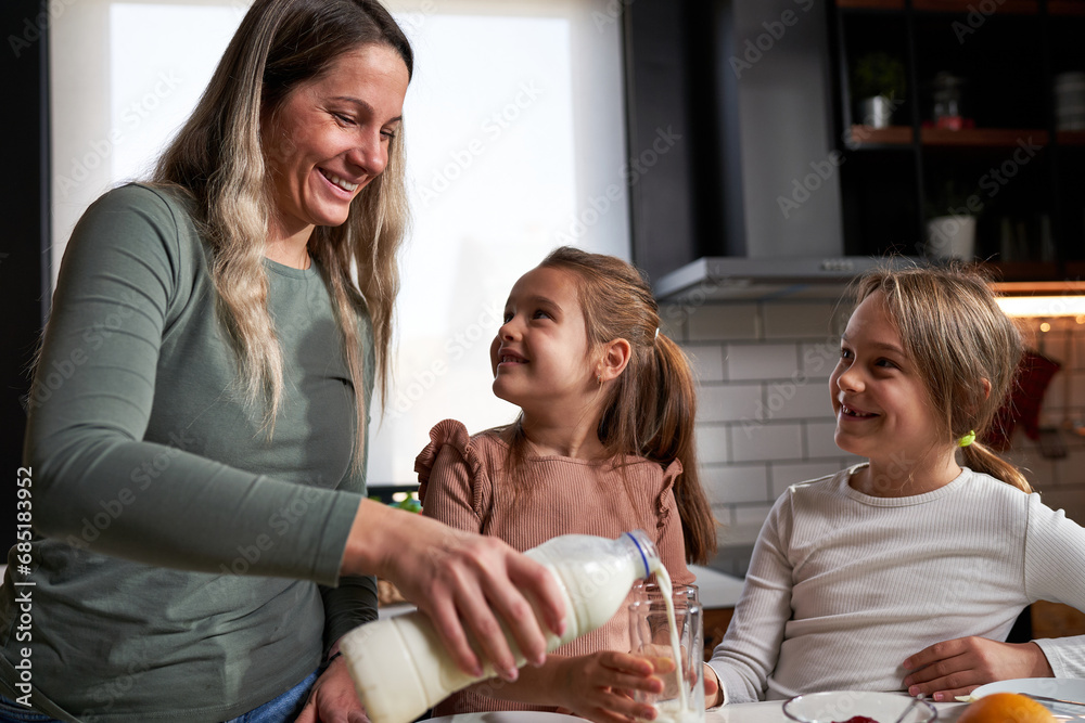 Sweet morning ritual: Mother and daughters joyfully spreading jam on bread, savoring the simple delight of a shared, sweet breakfast. Sweet morning ritual: Mother and daughters joyfully spreading jam on bread, savoring the simple delight of a shared, sweet breakfast.