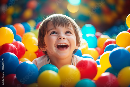 A child is playing in a ball pit. Colorful toys for children. A playroom in a kindergarten or preschool. A kid on an indoor playground in kindergarten. Children's pool with balloons. Preschooler's Bir photo