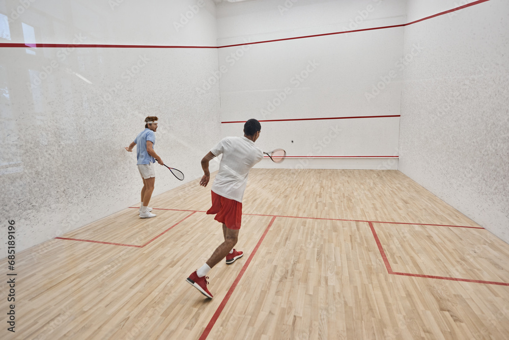 multicultural friends in sportswear playing squash together in court, motivation and sport
