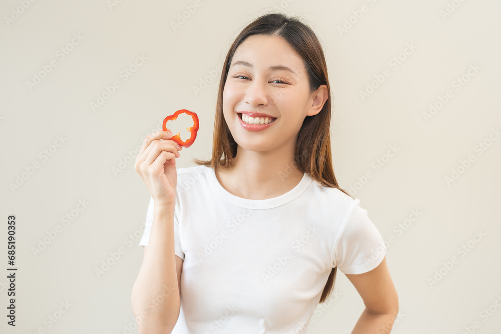 Healthy diet food with capsicum, portrait smile of asian young woman holding, eating red bell pepper isolated on background, fresh vegetable from nature organic for wellness, happy nutrition lifestyle Healthy diet food with capsicum, portrait smile of asian young woman holding, eating red bell pepper isolated on background, fresh vegetable from nature organic for wellness, happy nutrition lifestyle