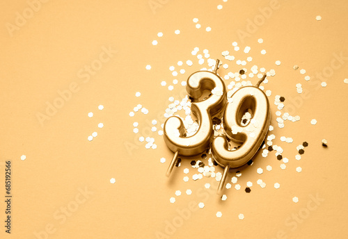 39 years birthday celebration festive background made with golden candle in the form of number Thirty nine lying on sparkles. Universal holiday banner with copy space. photo
