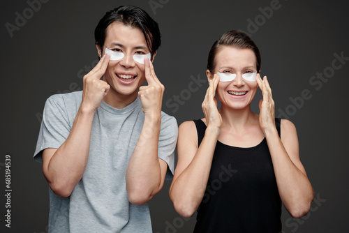 Diverse couple applying moisturizing undereye patches