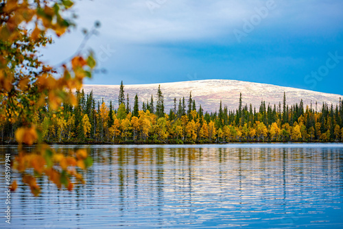 Kola Peninsula. Forest lake and autumn forest against the backdrop of the Lovozero Mountains
