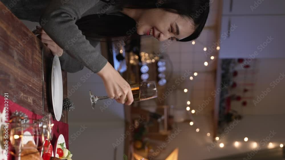 Vertical Screen: celebration people and holidays concept. smiling asian woman clinking glasses of alcoholic wine at home over christmas tree background. Vertical Screen: celebration people and holidays concept. smiling asian woman clinking glasses of alcoholic wine at home over christmas tree background.