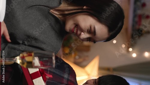 Vertical Screen: man making unexpected surprise present for charming girlfriend at date night at home. guy closing girl eyes with hands and sending gift on valentines day.