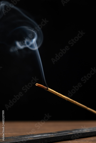 Smoke from a burning aroma stick on a black background. Incense sticks, aromatherapy and meditation.