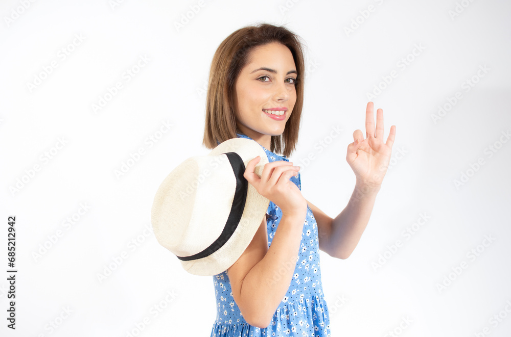 Young beautiful woman wearing casual dress standing over white isolated background smiling positive doing okay sign with hand and fingers. Successful expression. Young beautiful woman wearing casual dress standing over white isolated background smiling positive doing okay sign with hand and fingers. Successful expression.