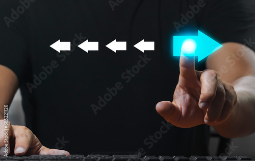 Hand pointing at blue arrows and different directions facing opposite direction with white arrows for business disruption and technology change and different thinking concepts. photo