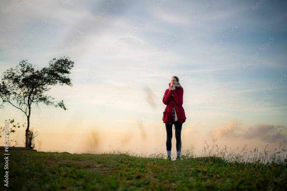 Portrait of a beautiful young woman in red coat on the background of blue sky Portrait of a beautiful young woman in red coat on the background of blue sky