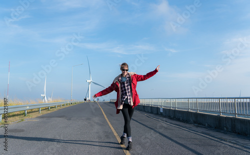 On the background of windmills  A young woman in a red jacket is enjoying her winter vacation.