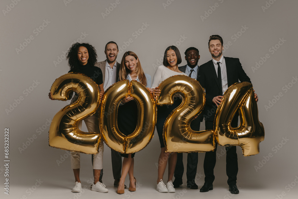 Φωτογραφία Group of happy business people in formalwear holding 2024 numbers while celebrat