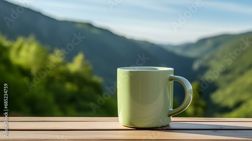 Close up of a light green Mug on a wooden Table in the Mountains. Blurred natural Background