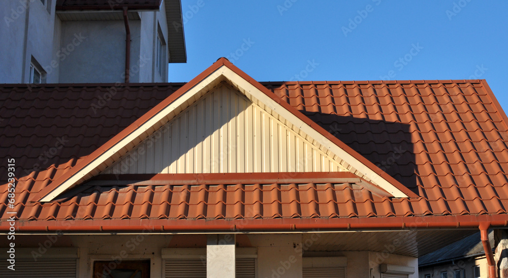 The roof of the house is covered with metal tiles The roof of the house is covered with metal tiles