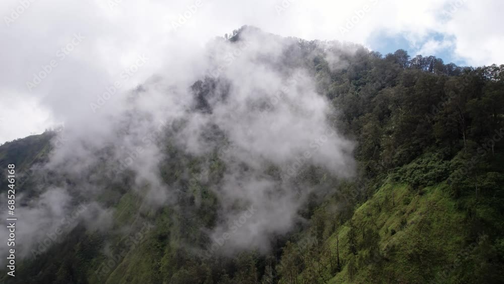 At higher altitudes on Mount Abang, ascent of streams of humid air leads to their gradual condensation, forming delicate and light clouds. As camera advances and ascends into ethereal realm At higher altitudes on Mount Abang, ascent of streams of humid air leads to their gradual condensation, forming delicate and light clouds. As camera advances and ascends into ethereal realm