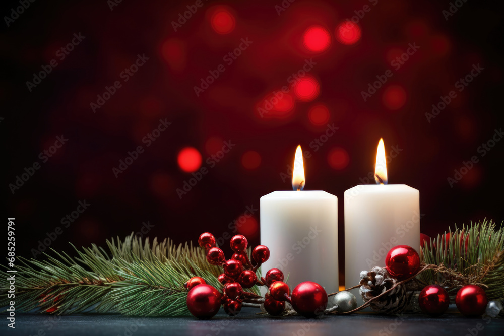 Christmas burning candles, fir branches and decorations on a dark red background