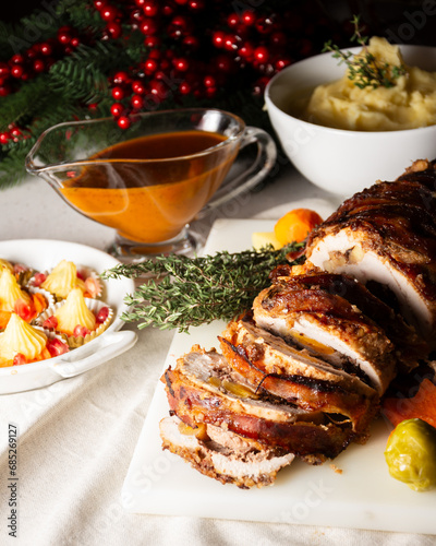 Close-up of cut stuffed turkey with sauce, vegetables and mashed potatoes, Christmas decoration, vertical