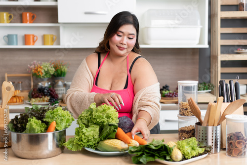 Happy Asia plus size woman prepare cooking vegetables salad in kitchen at home