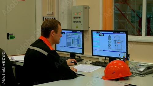 Industrial operator at plant checks machinery, ensuring industry standards. Focused on industry norms, operator oversees equipment with precision. Industry efficiency highlighted in monitoring tasks. photo
