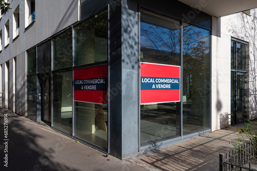 'Local commercial à vendre' écrit en Français sur deux affiches collées sur la fenêtre d'un local professionnel ou commercial. Concept de marché immobilier professionnel en France