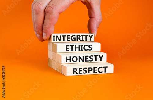 Integrity ethics honesty respect symbol. Concept word Integrity Ethics Honesty Respect on block. Beautiful orange background. Businessman hand. Business integrity ethics honesty respect concept.