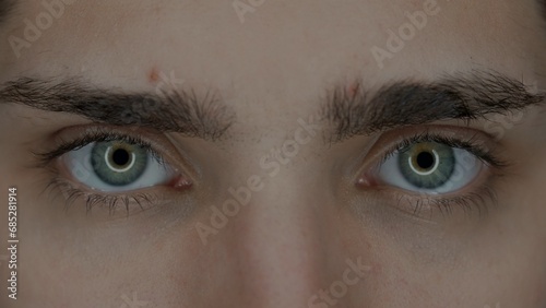 Eyes of a young man macro shot. Enlarged pupils, due to prolonged use of gadgets. Dry eye syndrome. Health concept. photo