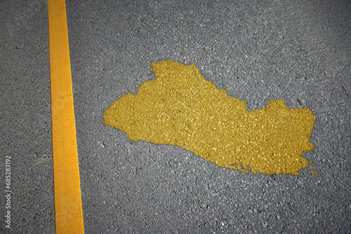 yellow map of el salvador country on asphalt road near yellow line. photo