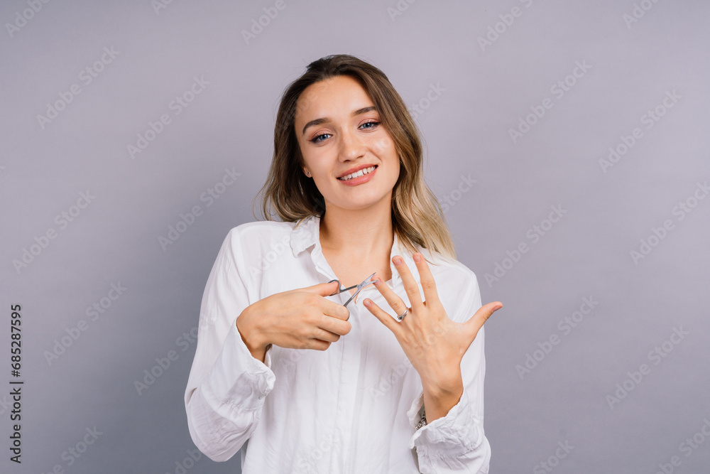 Close up young woman have tool cutting nails fingernails on finger using a nail clipper.