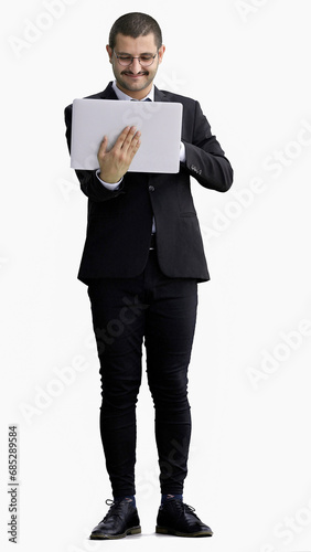 young man in full growth. isolated on white background using laptop