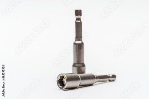 iron nozzle for roofing screws on a white background. metal adapter for screwing in self-tapping screws on a light background. reinforced bolt socket