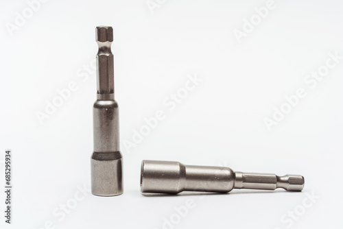 iron nozzle for roofing screws on a white background. metal adapter for screwing in self-tapping screws on a light background. reinforced bolt socket