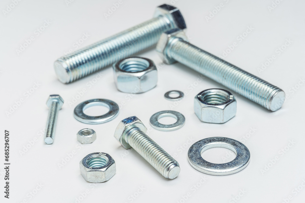 bolts nuts and washers on a white background. texture of fasteners on a light background. bolts nuts and washers on a white background. texture of fasteners on a light background.