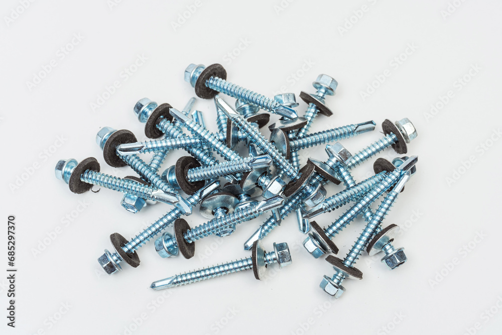 roofing screws on a white background. photo of self-tapping screws for the catalog on a light background. set of bolts for working with metal tiles and iron roofing screws on a white background. photo of self-tapping screws for the catalog on a light background. set of bolts for working with metal tiles and iron