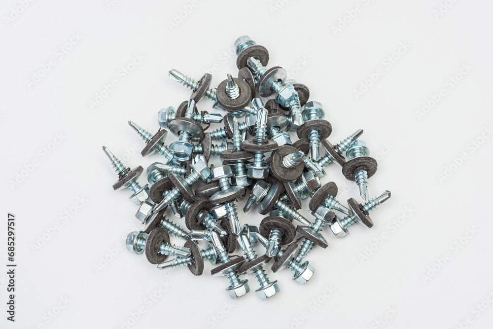 roofing screws on a white background. photo of self-tapping screws for the catalog on a light background. set of bolts for working with metal tiles and iron roofing screws on a white background. photo of self-tapping screws for the catalog on a light background. set of bolts for working with metal tiles and iron