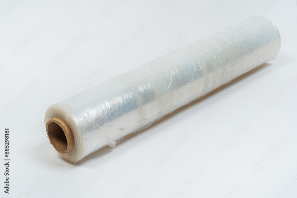 transparent film for packaging goods on a white background. film to protect the box from damage on a light background. cling film on roll transparent film for packaging goods on a white background. film to protect the box from damage on a light background. cling film on roll